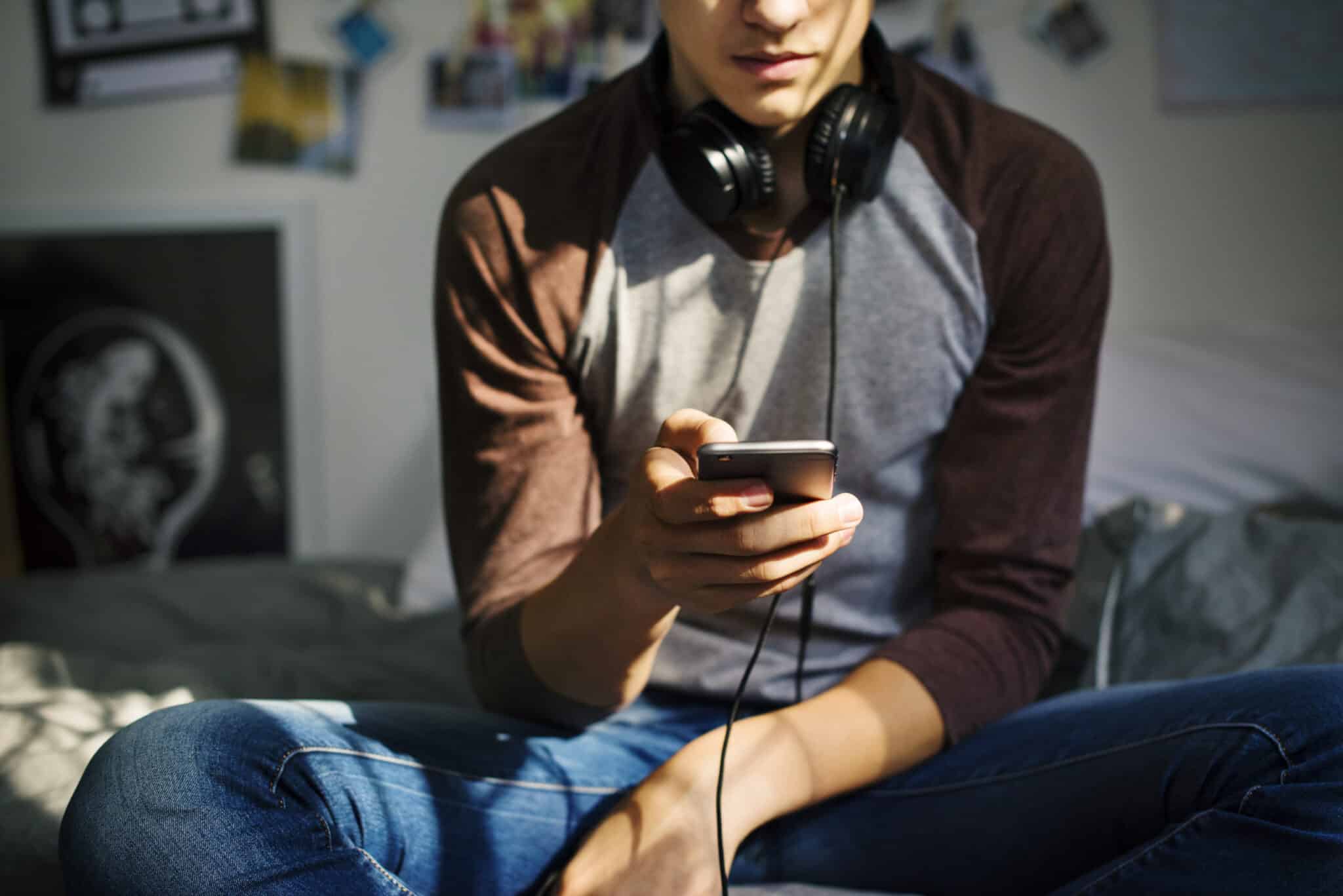 photo: Young man looking at cell phone